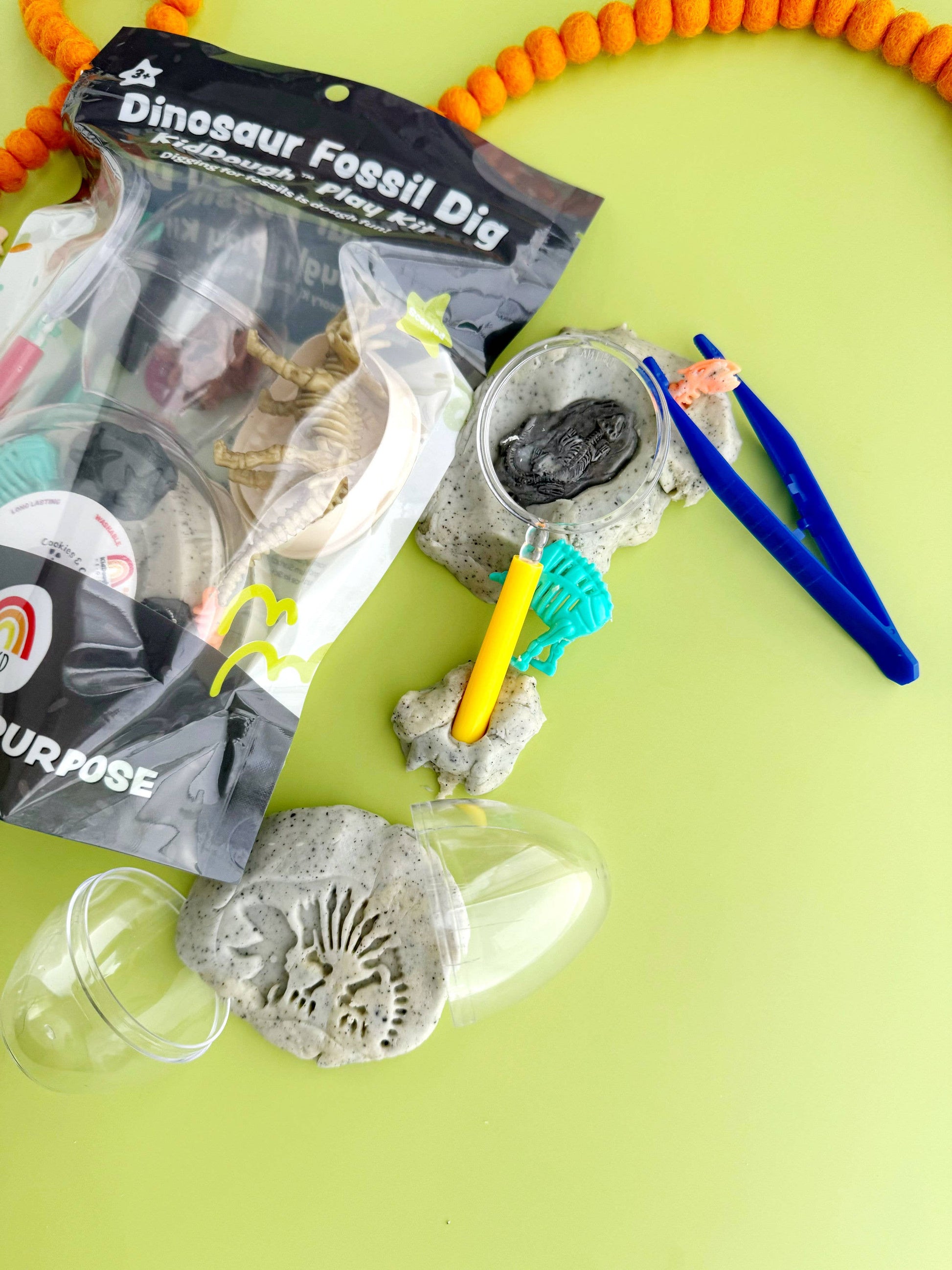 Dinosaur Fossil Dig KidDough Play Kit with realistic excavation tools and molds for educational play in natural clay color